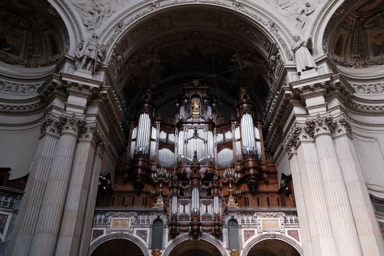 一座巨大的管风琴架在教堂内部一侧拱门之上，拥有深红棕色充满光泽的的红木质镶边与雕像，金属管主体在当日的阳光下散发出耀眼的银色光芒