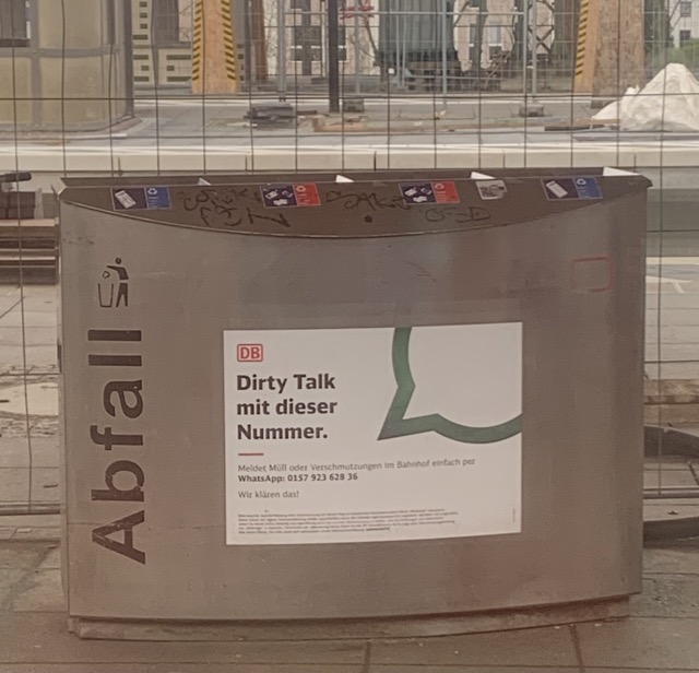 地铁站台上一个印着幽默标语的德国铁路公司垃圾箱。上面用德语写着：“Dirty Talk 热线”