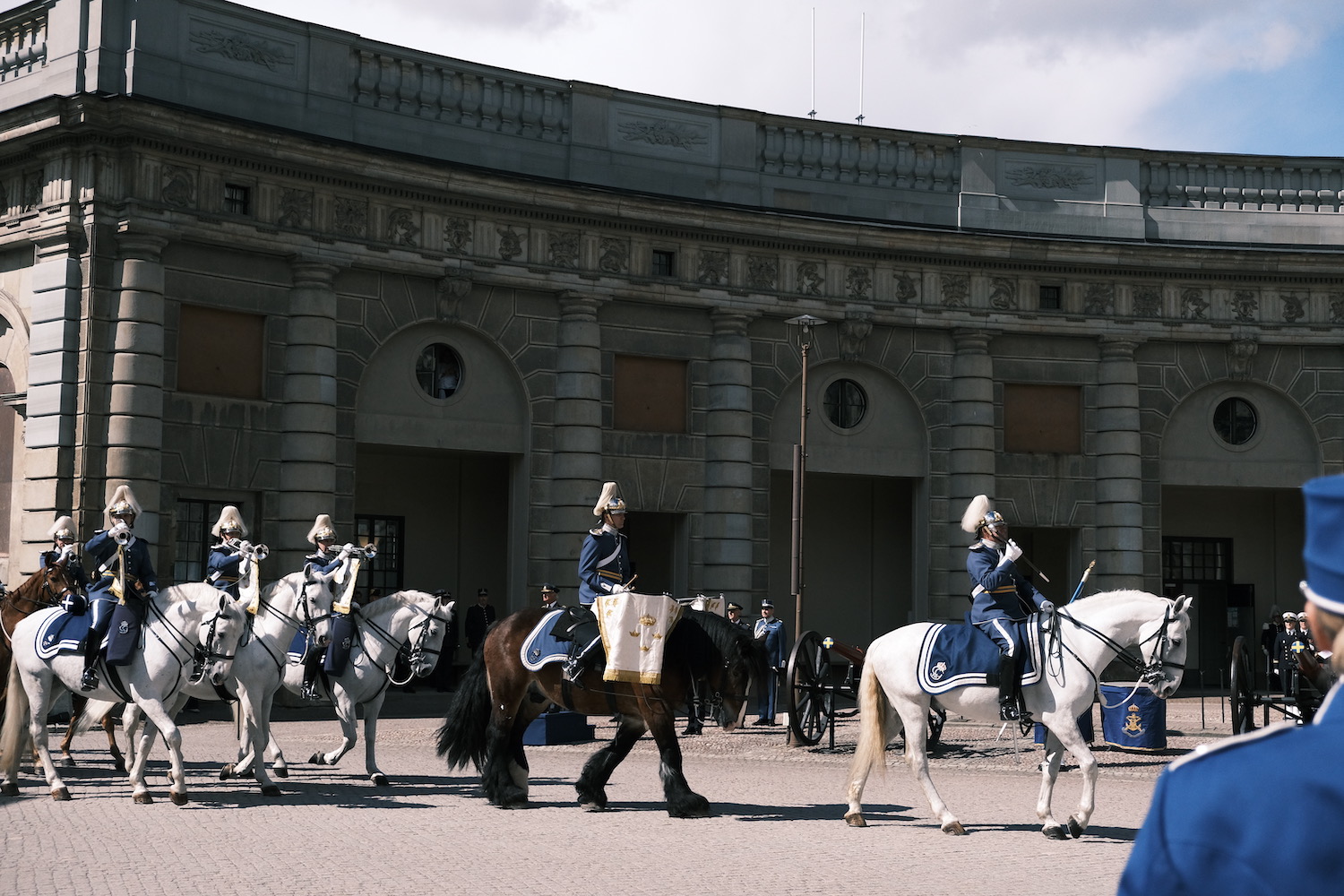 骑兵方阵正在进入广场，一手勒马一手手持管号正在吹奏。